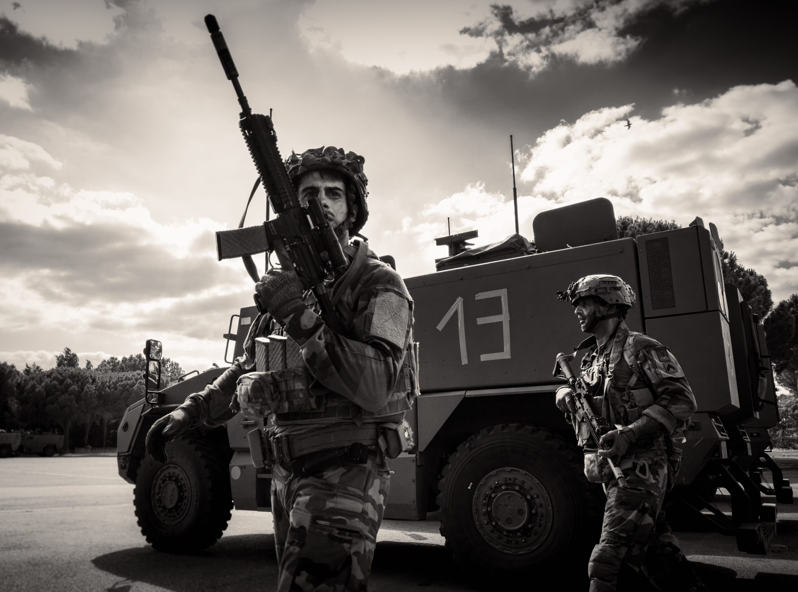 Deux militaires du 3e RPIMa se trouvent devant un véhicule blindé Serval, en fin d'après-midi